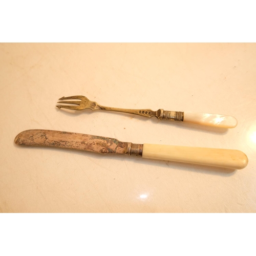 405 - An antique bone handled butter knife with sterling silver collar and a pickle fork.