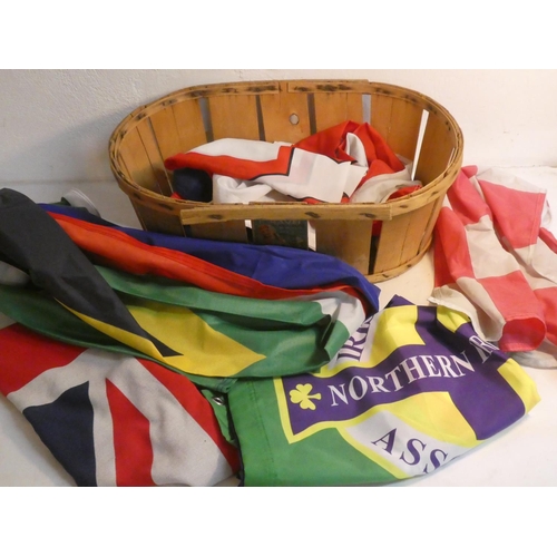 514 - A lot of assorted fabric flags in a wicker basket.