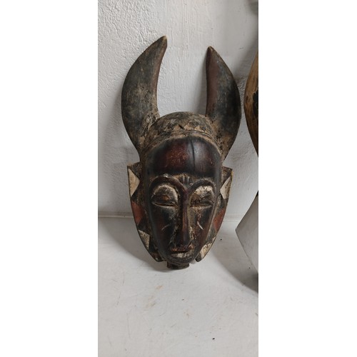 75 - A hand carved wooden tribal mask, measuring 36cm and wooden mask in the style of an animals head, me... 