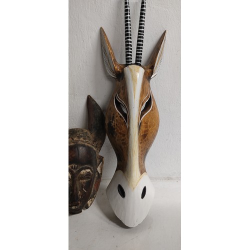 75 - A hand carved wooden tribal mask, measuring 36cm and wooden mask in the style of an animals head, me... 