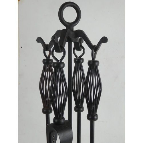 157 - A wrought iron fireside companion set.