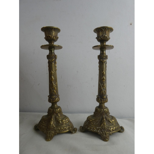 229 - A pair of decorative brass candlesticks, measuring 22cm.