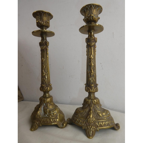 229 - A pair of decorative brass candlesticks, measuring 22cm.