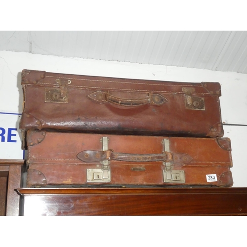 283 - Two antique leather luggage cases.