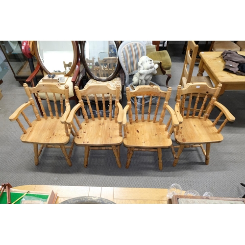 556 - A set of four pine bow back carver chairs.