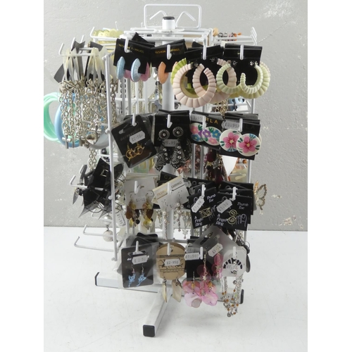 129 - A table top jewellery stand and a large quantity of new fashion jewellery.