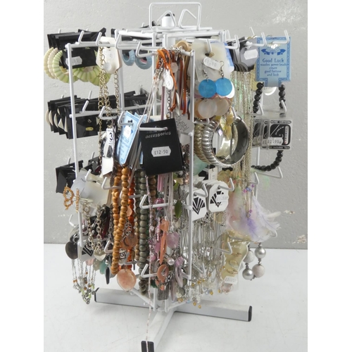 129 - A table top jewellery stand and a large quantity of new fashion jewellery.