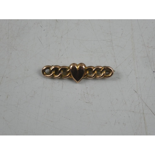 148 - A 9ct gold brooch with heart shaped detail, weighing 1.29g.