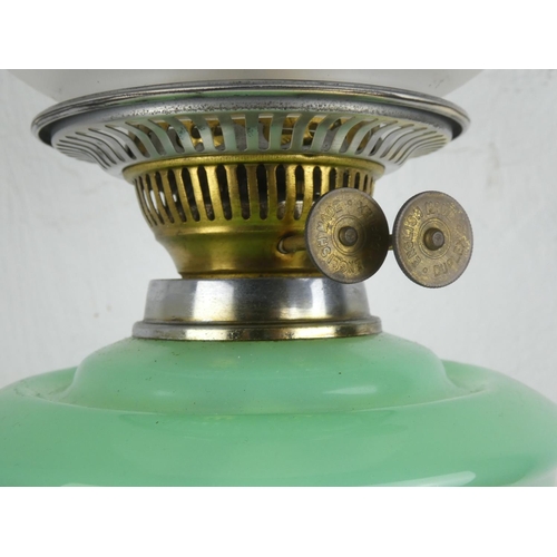 141 - A vintage oil lamp with green glass font.