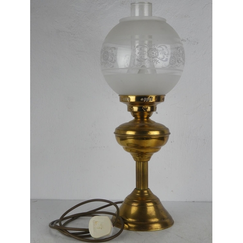 143 - An antique brass based oil lamp with etched glass shade, which has been electrified.