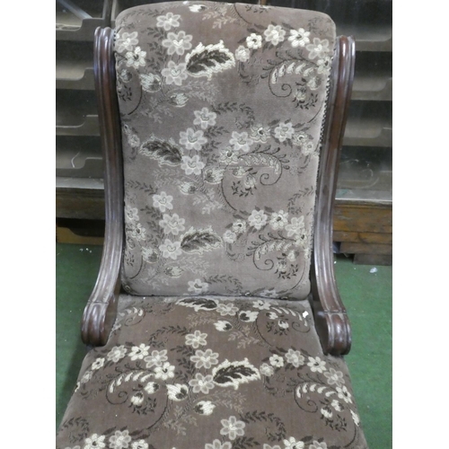 298 - An antique mahogany upholstered fireside chair.