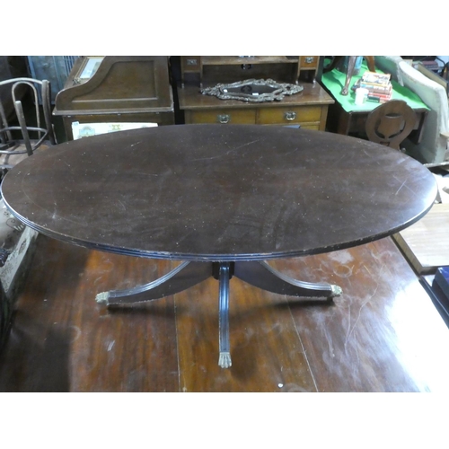 277 - A mahogany oval centre table with brass claw feet.