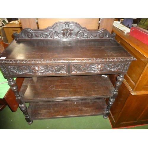 257 - A stunning antique carved oak dumb waiter with 'Green Man' design & mask handle drawers.