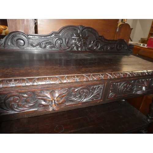 257 - A stunning antique carved oak dumb waiter with 'Green Man' design & mask handle drawers.