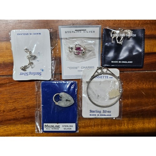 220 - A collection of 5 vintage Sterling Silver charms.