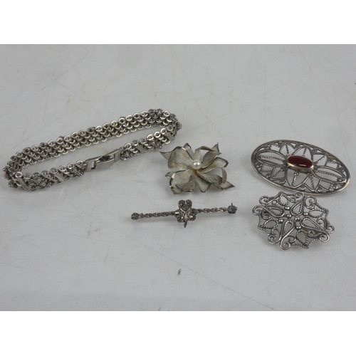 6 - Four Sterling Silver brooches and a bracelet.