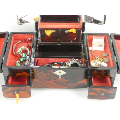 84 - A large oriental style jewellery box with contents and a silk fan.