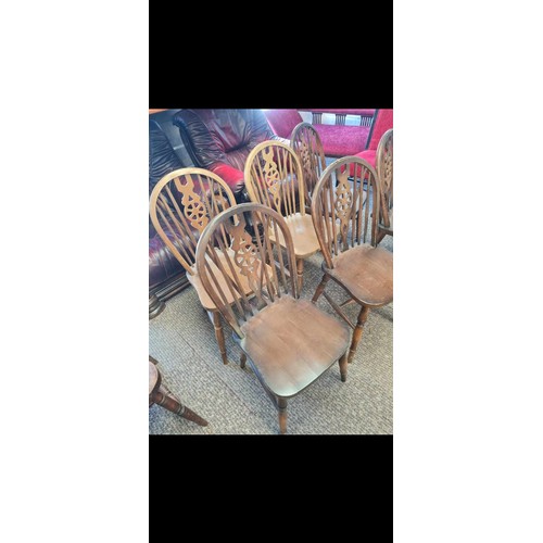 128 - Six wheel back style wooden chairs