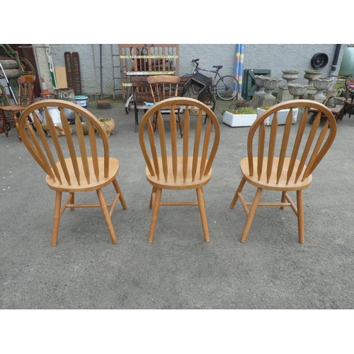 242 - A set of three pine kitchen chairs.