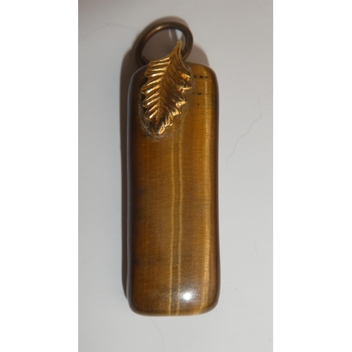 275 - A vintage tiger eye pendant with yellow metal leaf.