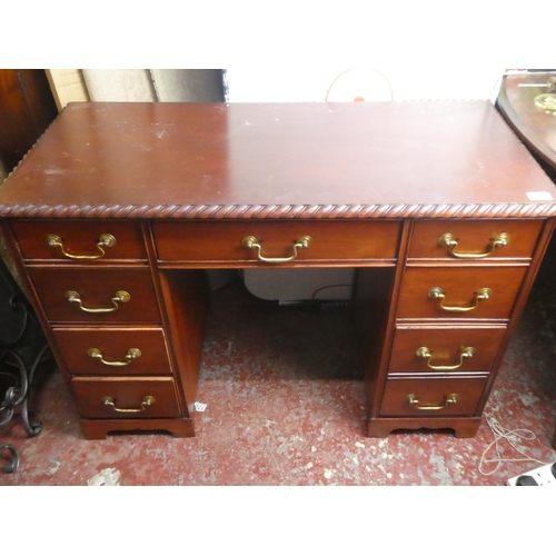 A small desk with decorative edging on top.