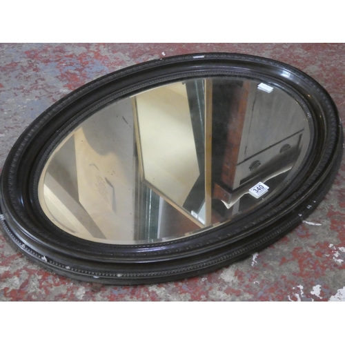 340 - A large oval framed wall mirror.  Measuring approx 88x62cm.