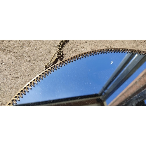 391 - A circular wall mirror on a metal chain, measuring 14