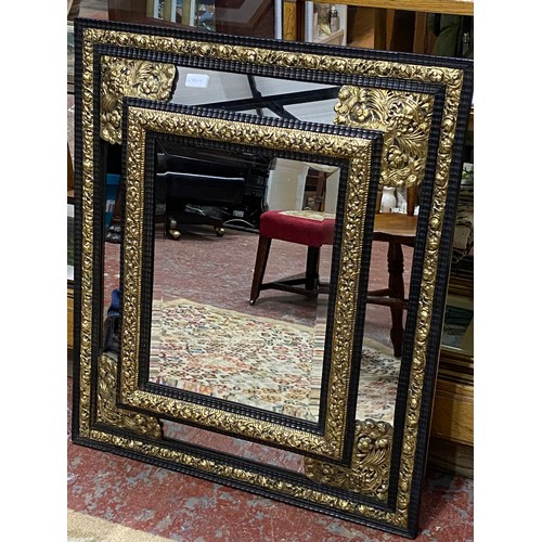 331 - A stunning French brass and ebony framed wall mirror, measuring 72cm x 84cm.