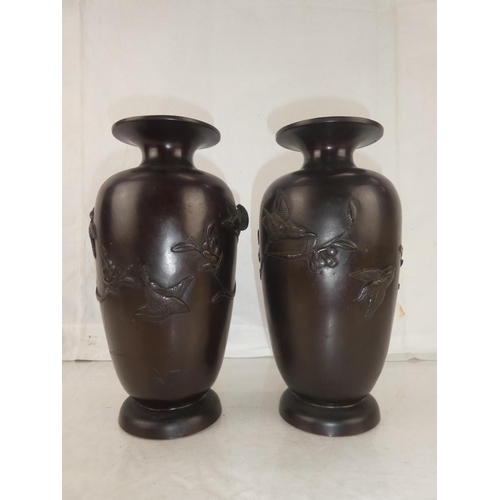 30 - A pair of antique bronze urns with Oriental design, each measuring 10