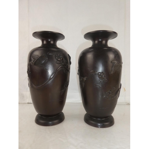 30 - A pair of antique bronze urns with Oriental design, each measuring 10