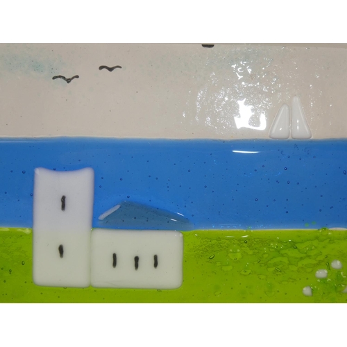 138 - A small framed studio glass panel of a church and boat, measuring 7