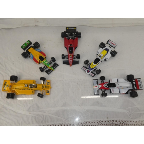 159 - A lot of five Burago Formula One toy racing cars to include McLarnen, Lotus and more.