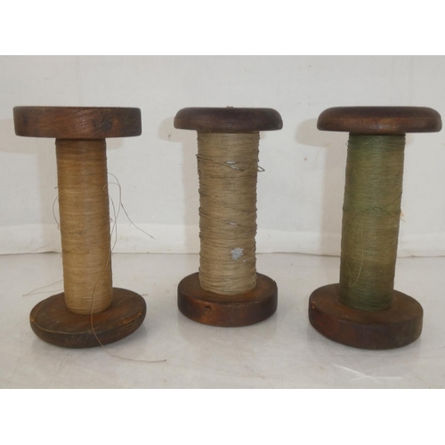 176 - Three large antique wooden spools of thread, measuring 19.5cm.