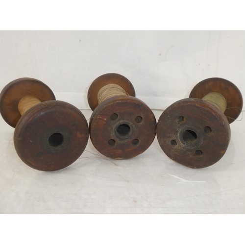 176 - Three large antique wooden spools of thread, measuring 19.5cm.