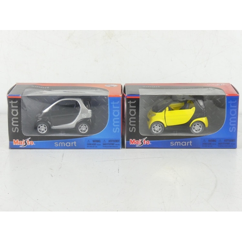 229 - Two boxed Maisto smart toy cars.