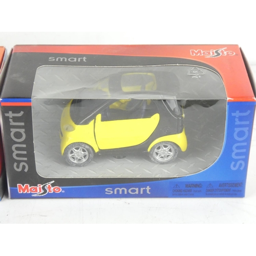 229 - Two boxed Maisto smart toy cars.