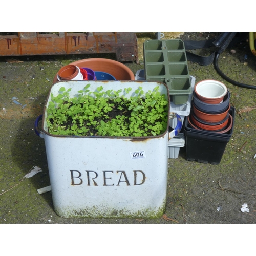 606 - A vintage enamel bread bin used as a planter and other plant pots.