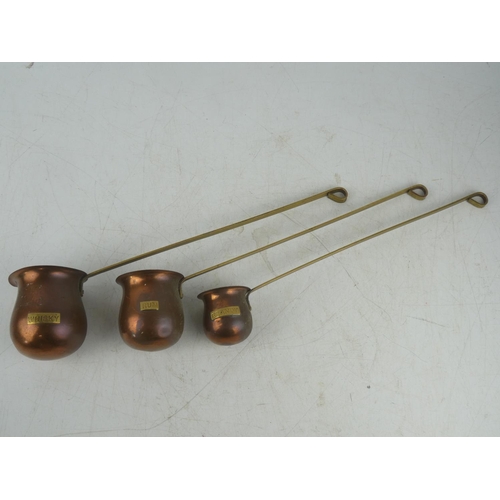 25 - A set of three vintage copper measures.