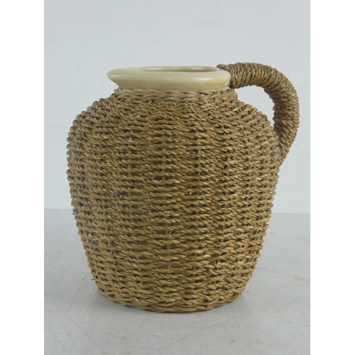 49 - An old water jug with basket weave cover, interior of yellow ware pottery.