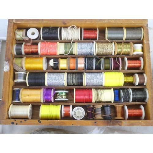 92 - A mixed lot of fly fishing/tying material to include a wooden box of assorted tinsel spools thread a... 