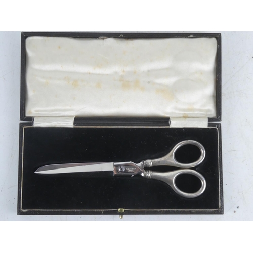 102 - A cased pair of Sterling Silver handled scissors.