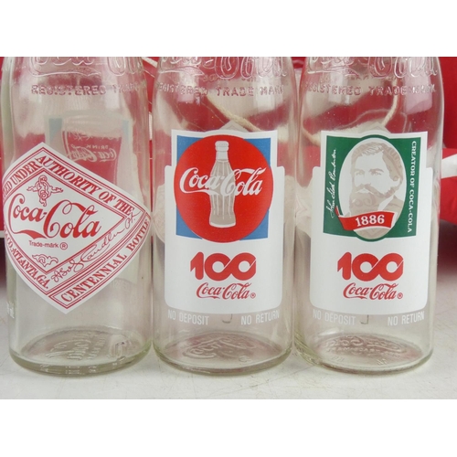 130 - Three vintage Coca Cola bottles and a Coca Cola sports bag.