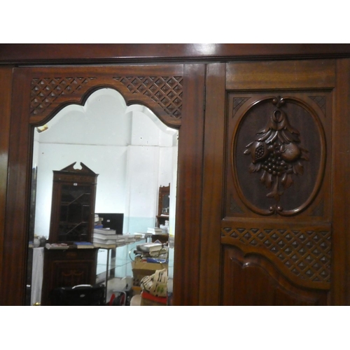 142 - A stunning antique mahogany wardrobe with carved panels and mirror.