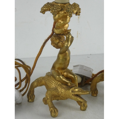 162 - A stunning pair of heavy brass table lamp bases in the style of a crocodile and cherub, measuring 32... 