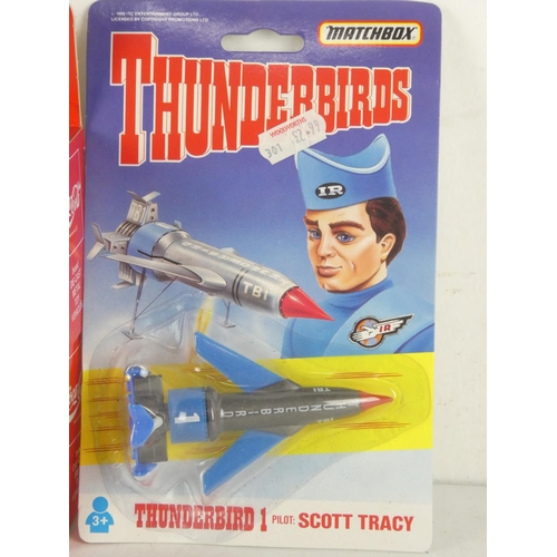 283 - Two boxed Coca Cola toy cars and another boxed Matchbox Thunderbirds plane.