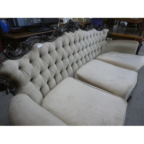 507 - An antique style three seater couch with button back detail and carved frame.