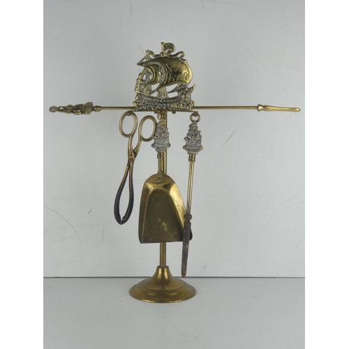 23 - A vintage four piece brass companion set with ship detail.