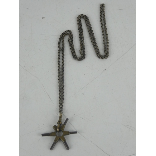 31 - A metal belcher chain and a pendant with clock keys.