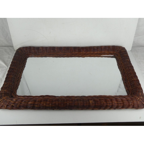 6 - A vintage rattan framed wall mirror. Measuring 74cm x 50cm