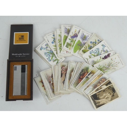 8 - A collection of vintage cigarette cards and a cased Win International cigarette lighter.